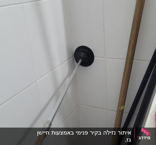 פומפה עם ידית ארוכה על קיר אריחים לבן